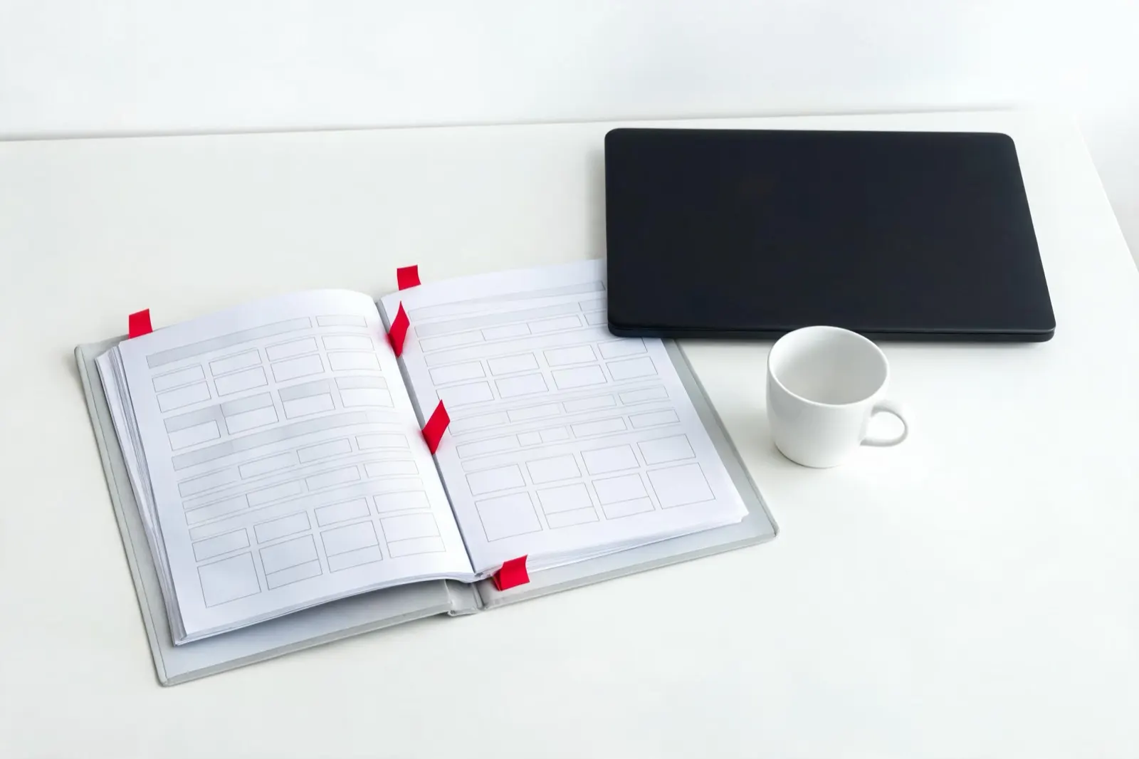 Aufgeschlagene Mappe mit Fragebogen und roten Markierungen neben einem Notebook (KI-generiertes Bild)